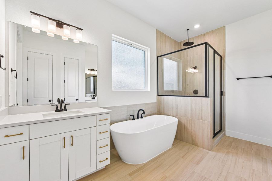 A well-lit primary bathroom featuring a freestanding tub and a spacious glass-enclosed shower. A well-lit primary bathroom featuring a freestanding tub and a spacious glass-enclosed shower.