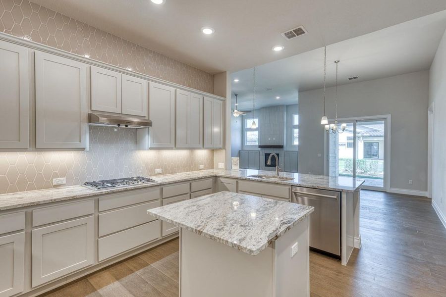 Kitchen with a peninsula, tasteful backsplash, recessed lighting, appliances with stainless steel finishes, and a center island