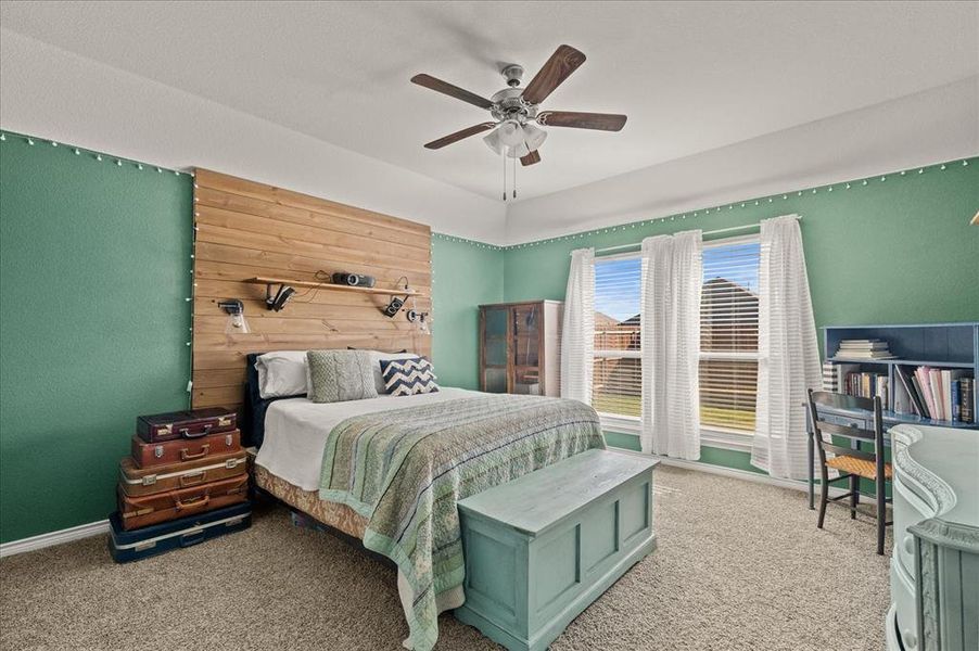 Carpeted bedroom featuring ceiling fan