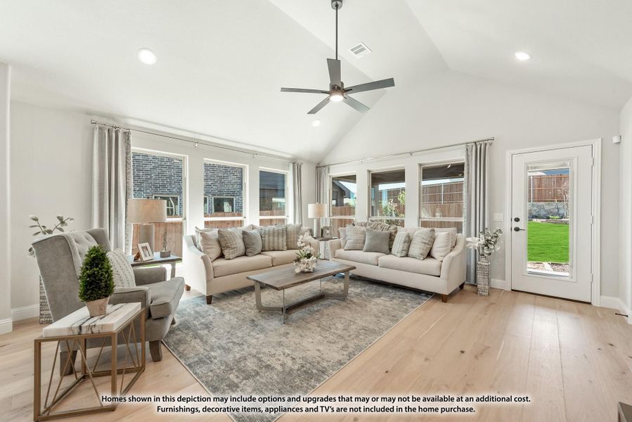 Living room with vaulted ceiling, ceiling fan, two sofas, and hardwood floors with backyard door access Living room with vaulted ceiling, ceiling fan, two sofas, and hardwood floors with backyard door access