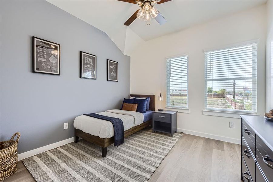Bedroom featuring light wood-style floors, vaulted ceiling, and ceiling fan