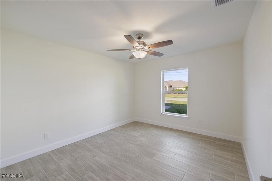 Empty room with wood finish floors and ceiling fan