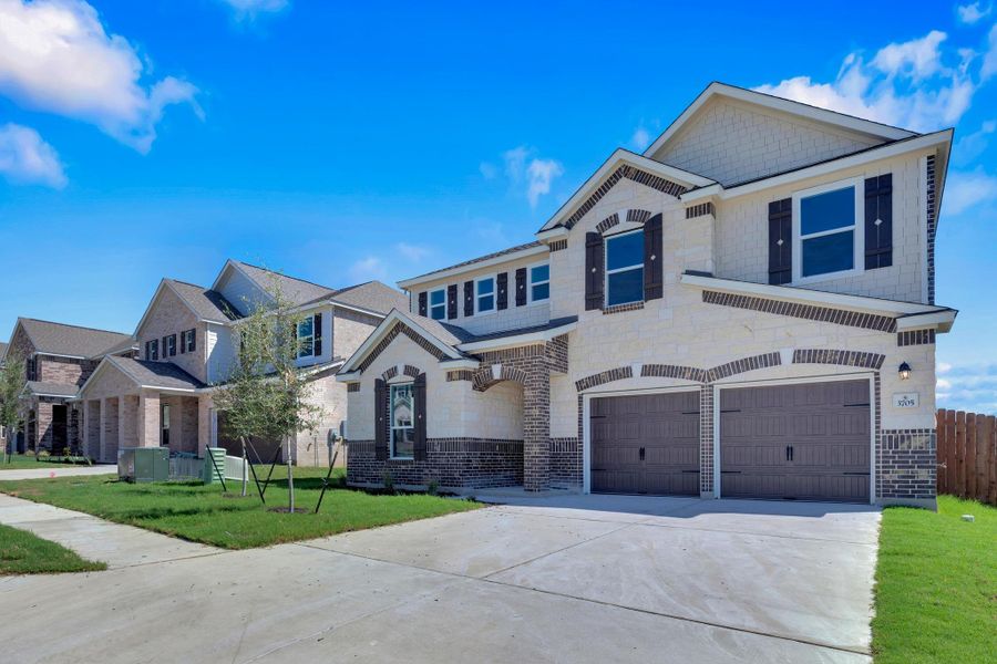 Front exterior of a new home in Salerno - Classic Collection, Round Rock, TX, highlighting curb appeal (Image 22). Front exterior of a new home in Salerno - Classic Collection, Round Rock, TX, highlighting curb appeal (Image 22).