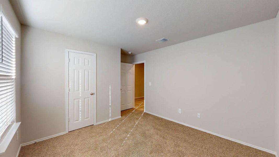 Unfurnished bedroom featuring light carpet and a closet