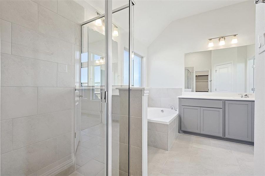 Bathroom with plus walk in shower, tile patterned floors, vanity, and vaulted ceiling