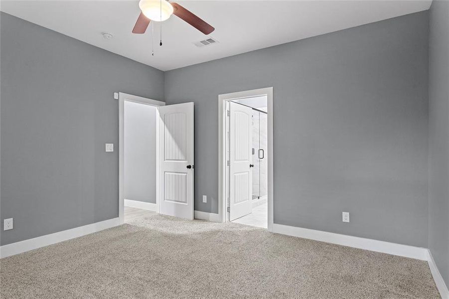 Unfurnished bedroom featuring light colored carpet and a ceiling fan Unfurnished bedroom featuring light colored carpet and a ceiling fan
