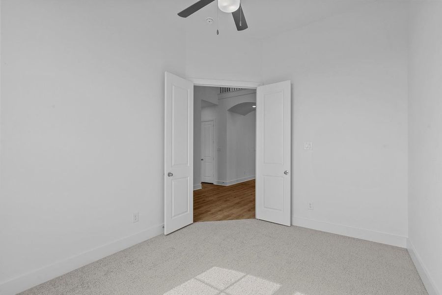 Unfurnished bedroom with baseboards, a ceiling fan, and carpet Unfurnished bedroom with baseboards, a ceiling fan, and carpet