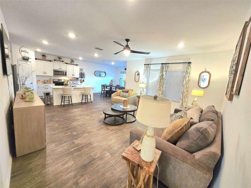 Open-concept living area featuring wood-finish flooring throughout, recessed lighting, and a ceiling fan