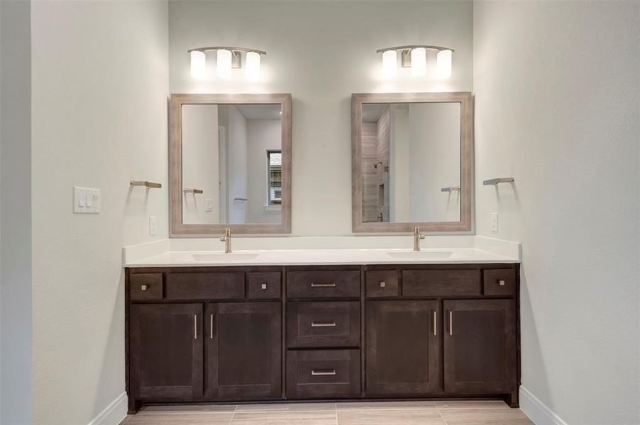 Bathroom with double vanity and baseboards