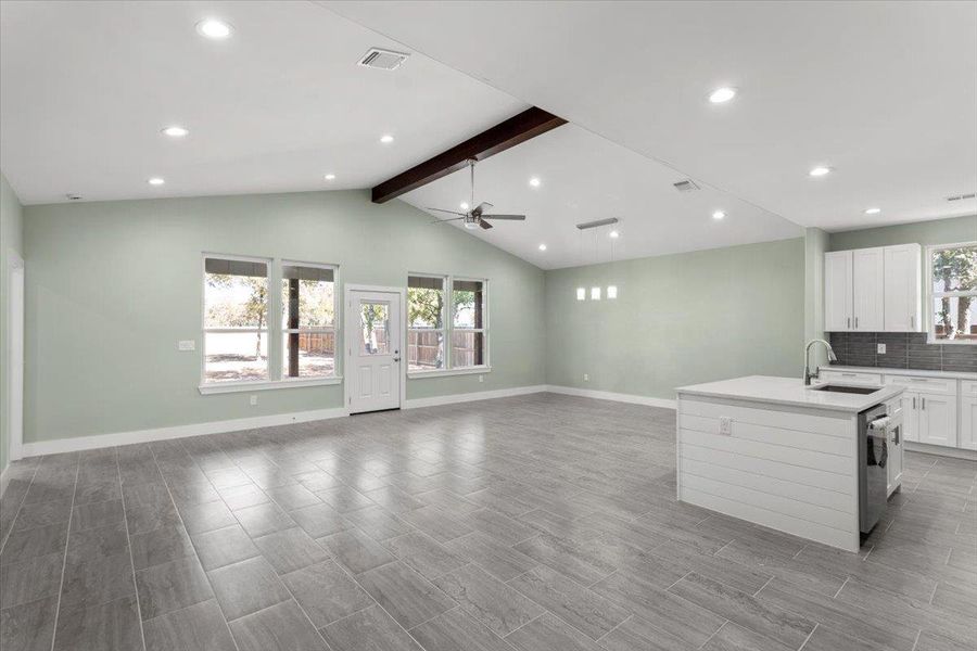 Kitchen featuring white cabinets, backsplash, recessed lighting, an island with sink, and ceiling fan