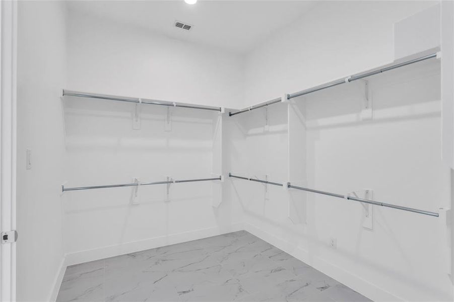 Walk in closet featuring light marble finish floors