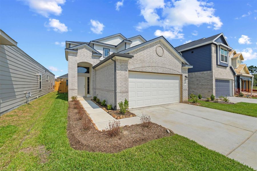 Front exterior of a new home in Woodland Lakes, Huffman, TX, highlighting curb appeal (Image 1).