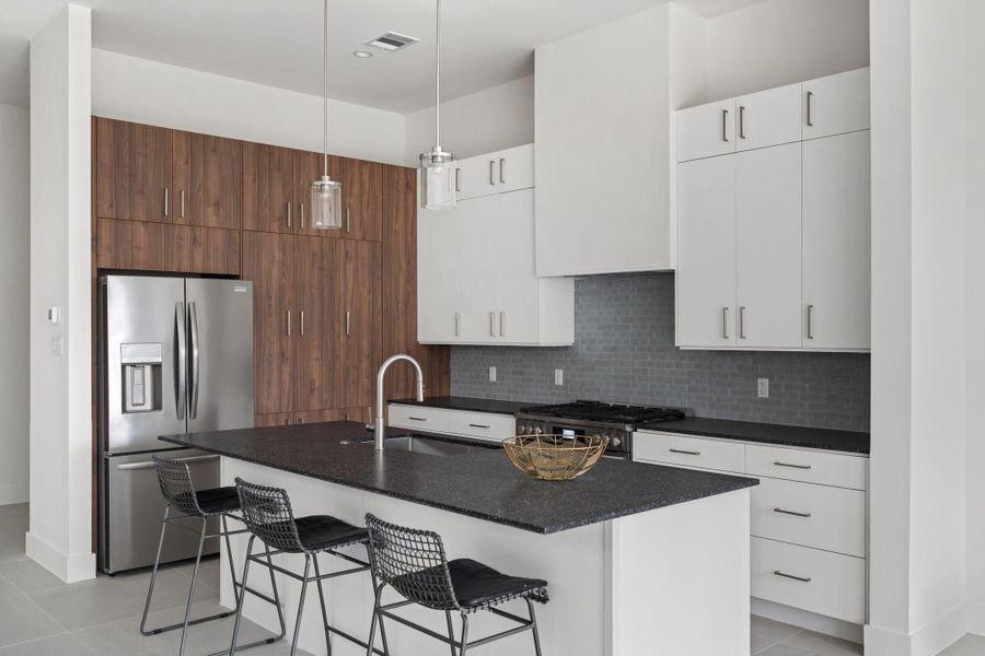 A chef’s dream kitchen with quartz countertops, a large island with seating, and high-end cabinetry by GoBravura. A chef’s dream kitchen with quartz countertops, a large island with seating, and high-end cabinetry by GoBravura.