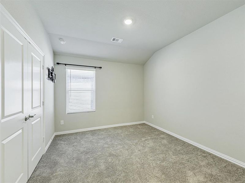 Carpeted spare room with lofted ceiling