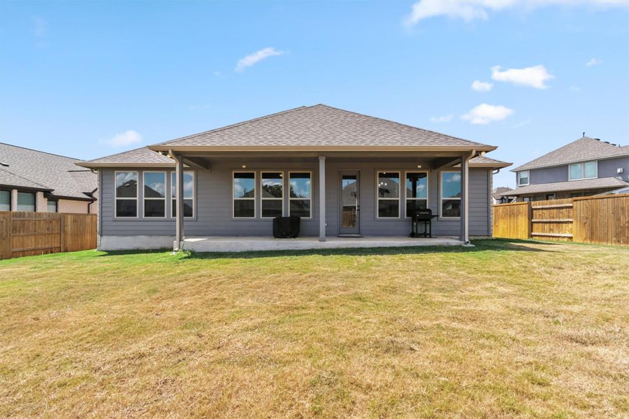 Rear view of property with a fenced backyard, a patio area, and roof with shingles Rear view of property with a fenced backyard, a patio area, and roof with shingles