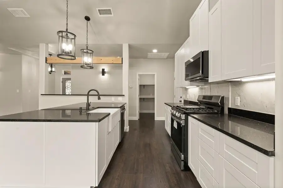 Kitchen with stainless steel appliances, dark wood-style floors, recessed lighting, decorative backsplash, and white cabinetry