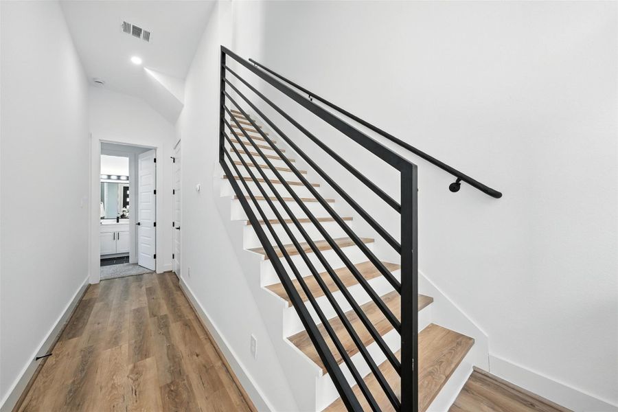 Modern entrance featuring a sleek staircase with clean architectural lines, wood treads, and a contemporary black metal railing. This stylish entryway is complemented by wide-plank flooring and high ceilings, creating a bright and sophisticated first impression. Modern entrance featuring a sleek staircase with clean architectural lines, wood treads, and a contemporary black metal railing. This stylish entryway is complemented by wide-plank flooring and high ceilings, creating a bright and sophisticated first impression.