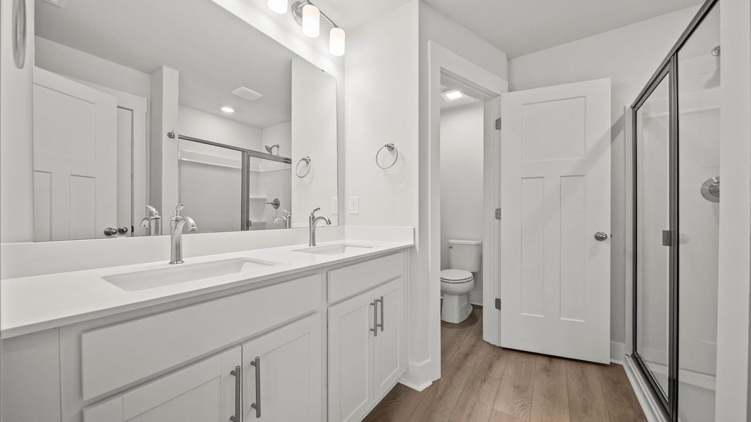 Spacious and modern primary bathroom with walk-in shower and first-class double vanity setup