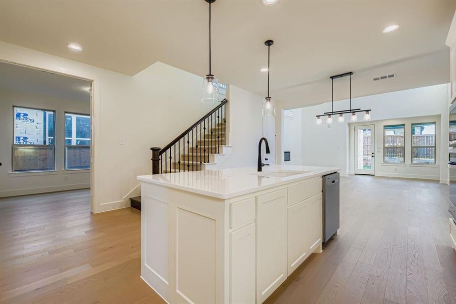 Kitchen with light wood-style floors, decorative light fixtures, open floor plan, and recessed lighting