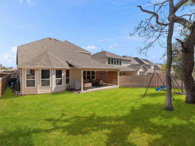 Back of house with a patio, a fenced backyard, and roof with shingles