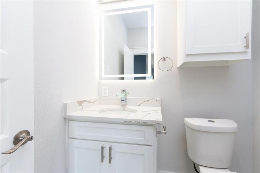 Half bathroom with vanity and toilet