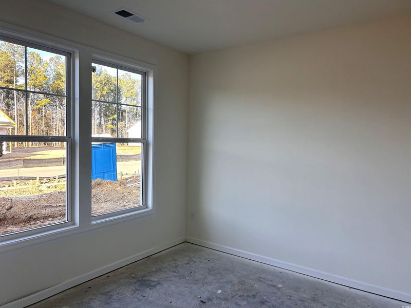 Empty room with unfinished concrete floors and baseboards