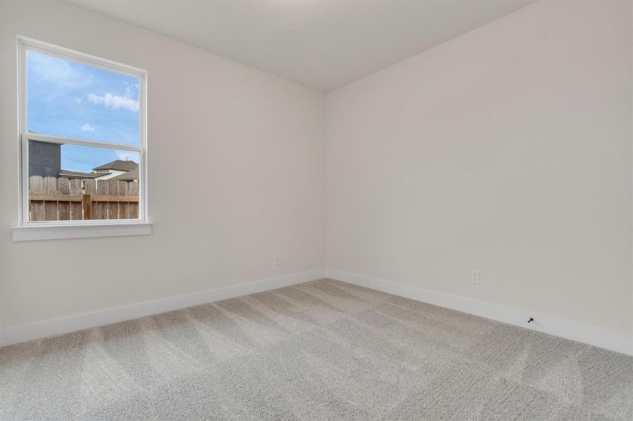 A window fills this versatile room with abundant natural light, offering a view of the neighborhood.
