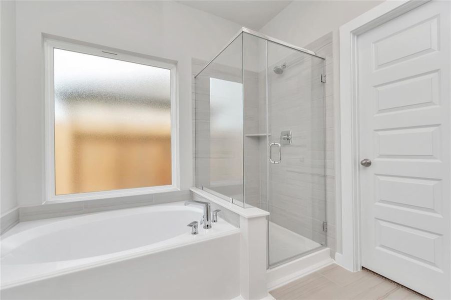 The primary en-suite has a soaking tub to give you that spa experience. The large privacy window allow lots of nature light in the space. Sample photo of completed home with similar floor plan. As-built interior colors and selections may vary