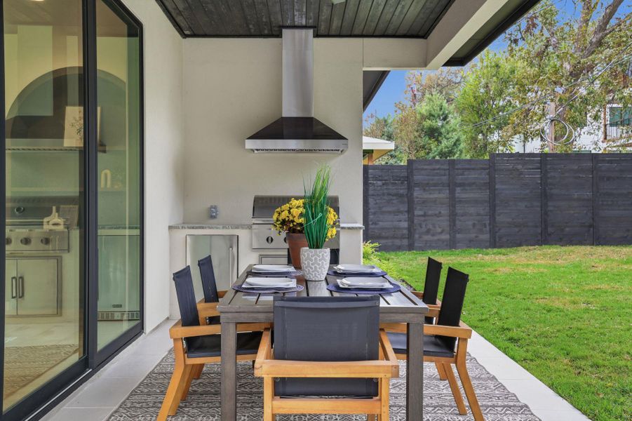 View of patio with outdoor dining space and exterior kitchen