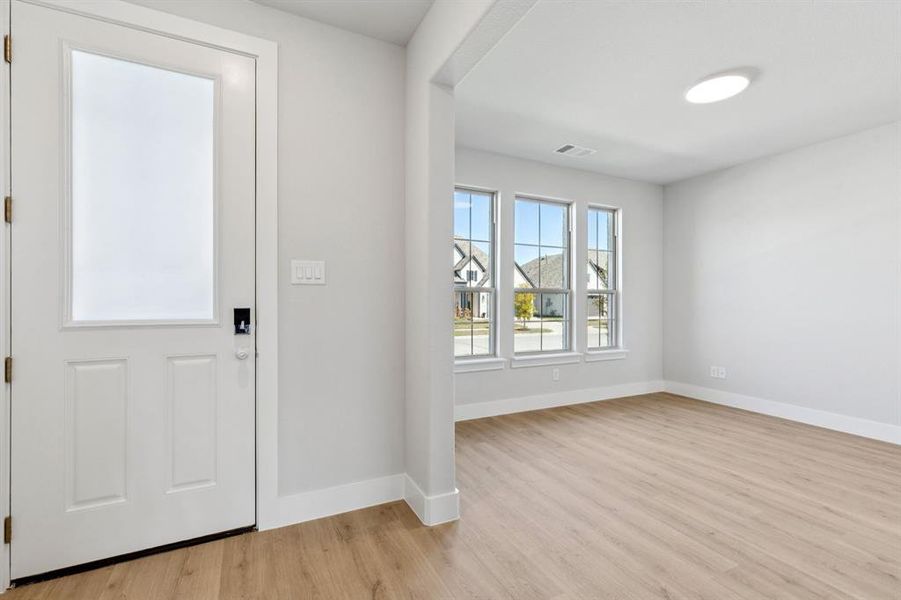 Entryway featuring light wood-style floors and baseboards Entryway featuring light wood-style floors and baseboards