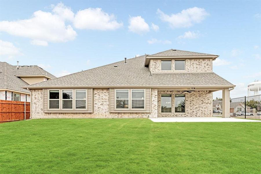 Back of house featuring a fenced backyard, roof with shingles, a patio, and brick siding