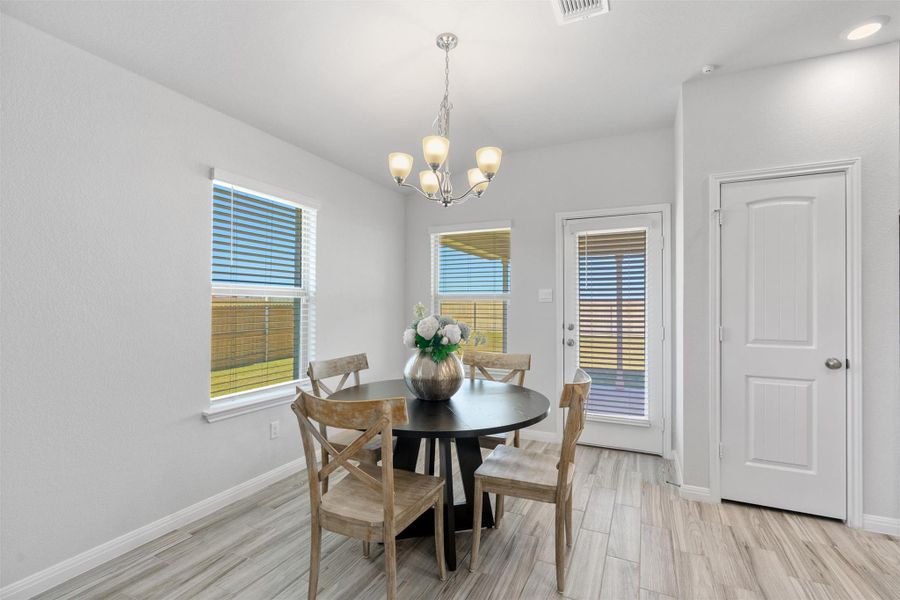 Dining space with light wood-style flooring and a chandelier