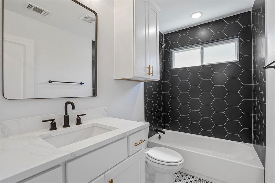 Bathroom featuring visible vents, toilet, bathtub / shower combination, and vanity