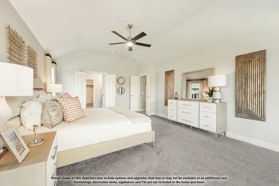 Master bedroom with vaulted ceiling, ceiling fan, carpet floors, white dresser, and walk-in closet entrance