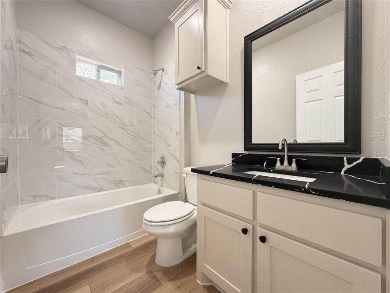 Bathroom with vanity, bathtub / shower combination, and light wood finished floors