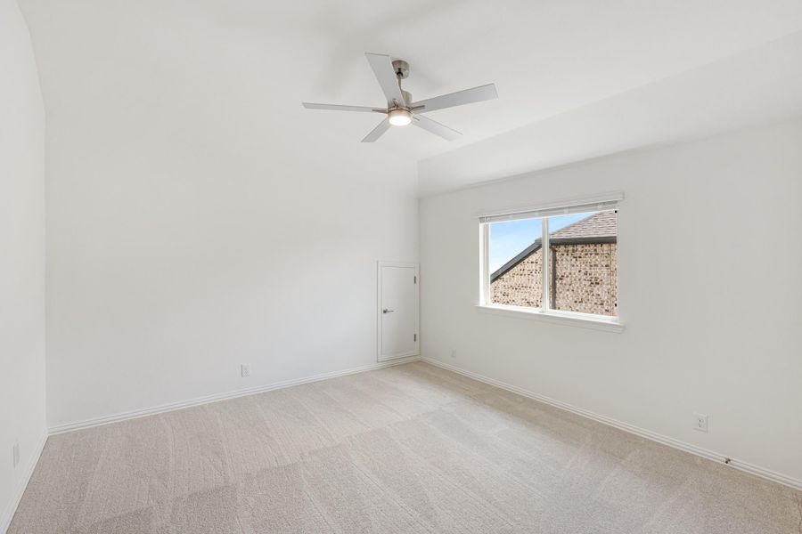 Empty bedroom with vaulted ceiling, ceiling fan, carpet flooring, and single window Empty bedroom with vaulted ceiling, ceiling fan, carpet flooring, and single window