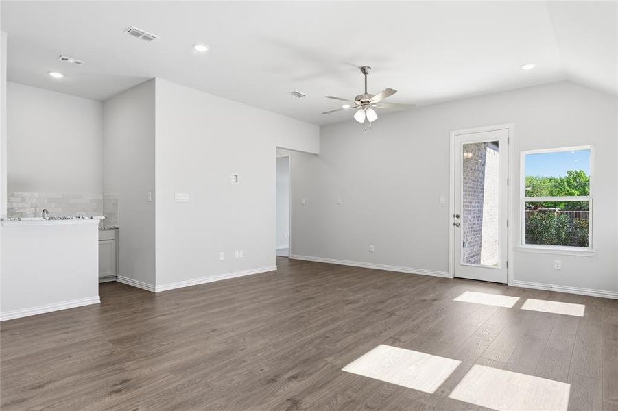 Unfurnished living room with recessed lighting, dark wood-type flooring, ceiling fan, and vaulted ceiling Unfurnished living room with recessed lighting, dark wood-type flooring, ceiling fan, and vaulted ceiling