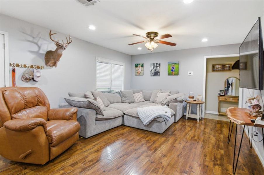Living area featuring wood-finish flooring, recessed lighting, and a ceiling fan