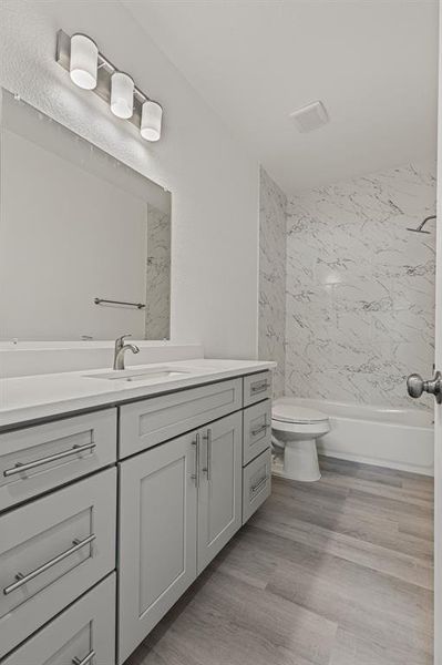 Bathroom with vanity, light wood-type flooring, and bathing tub / shower combination