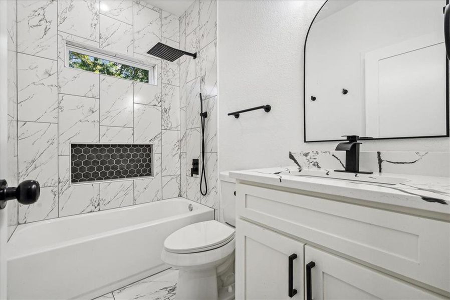 Full bathroom tiled shower / bath combo, vanity, and tile patterned floors