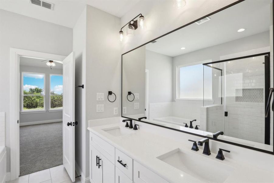 Bathroom with dual vanity, tile patterned floors, and independent shower and bath