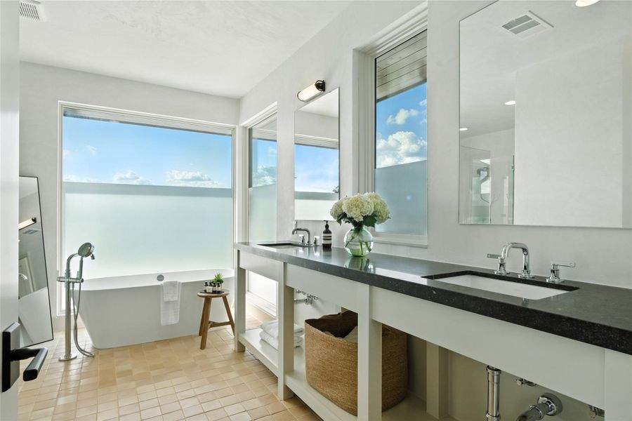 Full bath featuring double vanity and a soaking tub