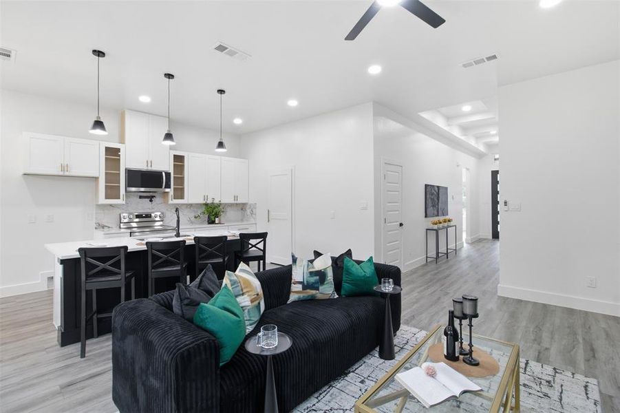 Open-concept living space featuring wood-finish flooring, recessed lighting, and a contemporary ceiling fan