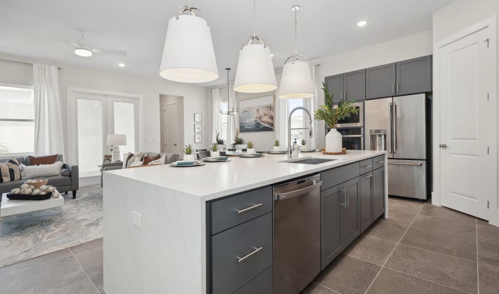 Sprawling island with waterfall quartz countertop