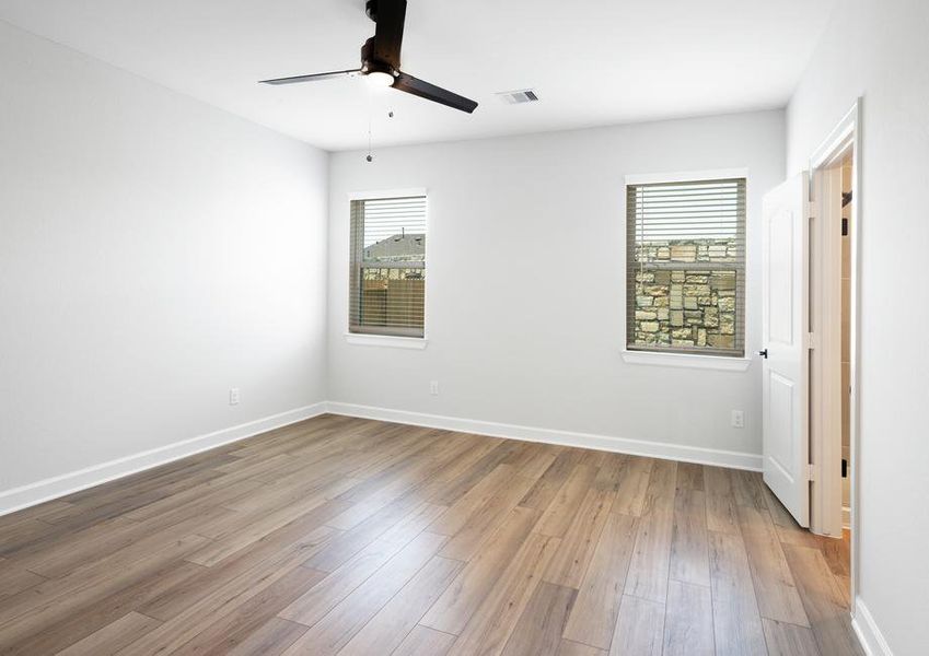 Master bedroom with ceiling fan and plank flooring