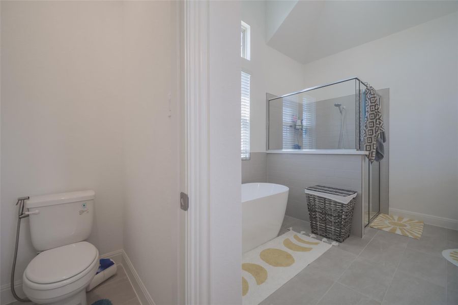 Indulge in this well-appointed bath, offering both a standalone soaking tub and a spacious glass-enclosed shower.