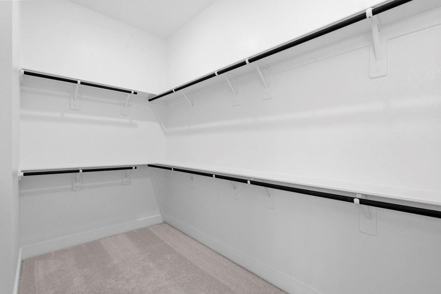 A spacious walk-in closet provides ample storage and organization, adding to the primary suite’s exceptional livability.