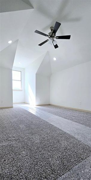 Bonus room featuring carpet, vaulted ceiling, and ceiling fan