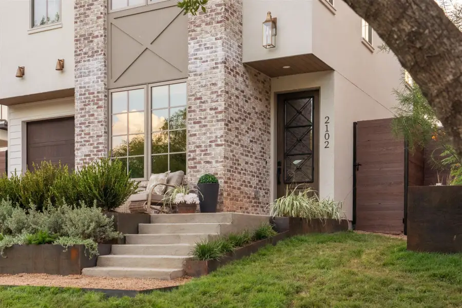Concrete steps ascend to a covered entryway flanked by timeless brick and stucco detailing. Concrete steps ascend to a covered entryway flanked by timeless brick and stucco detailing.