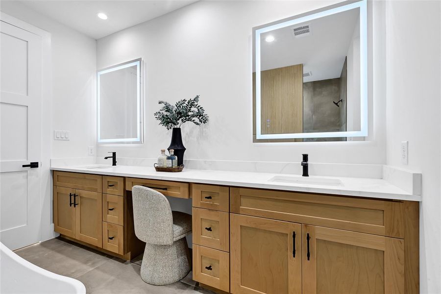 Primary bathroom with dual vanity, quartz countertops, and illuminated mirrors
